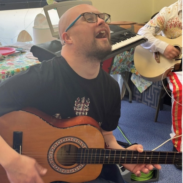 male jp eastleigh member singing with a guitar