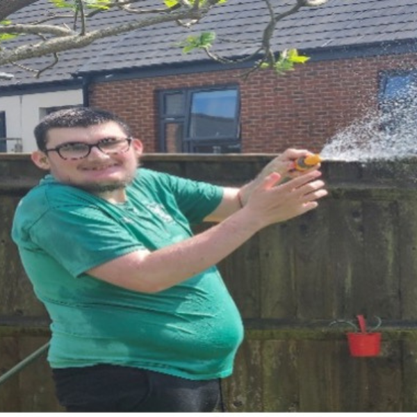 jp member playing with a hose pipe 