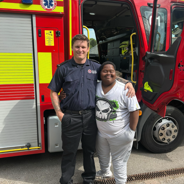 female JP Basingstoke member with a fireman against a red fire engine<br />

