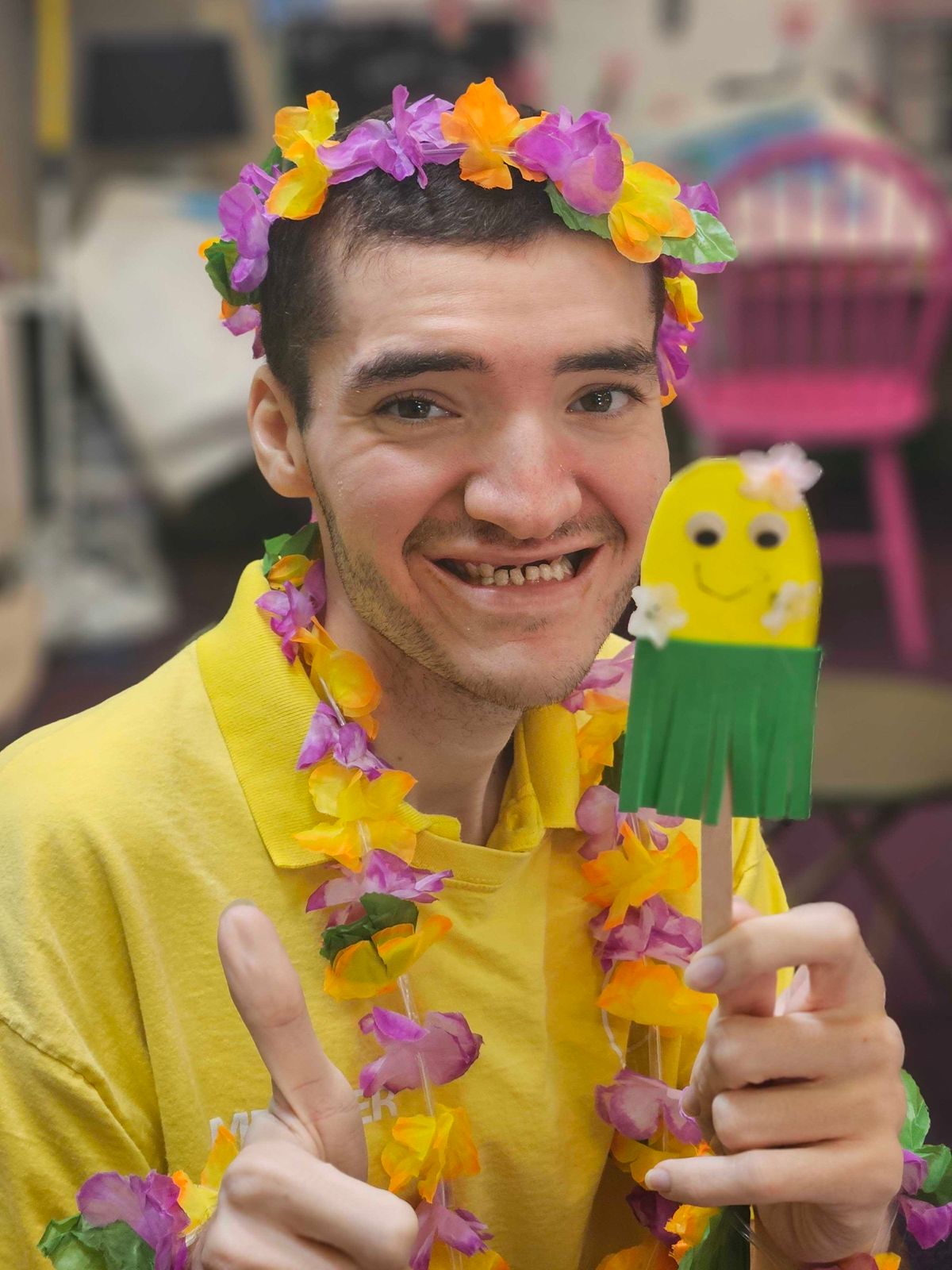 jp member looking really happy holding a hawian dancer inspired craft 